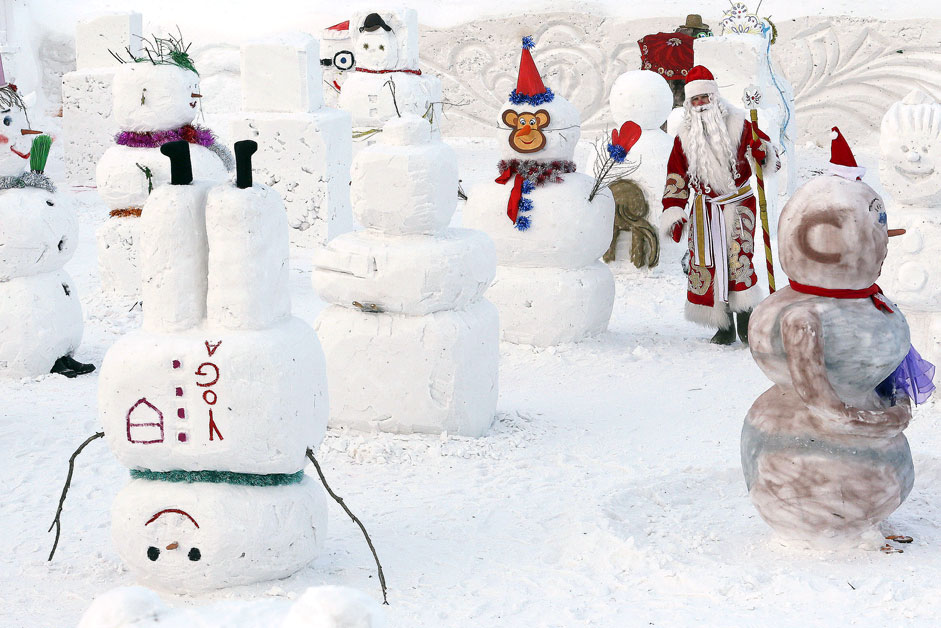 Човек облечен како Дедо Мраз го избира најдобриот снешко во текот на натпреварувањето „Парада на снешковци“ во Зоолошката градина „Роев Ручеј“ во предградието на сибирскиот град Краснојарск, Русија.   
