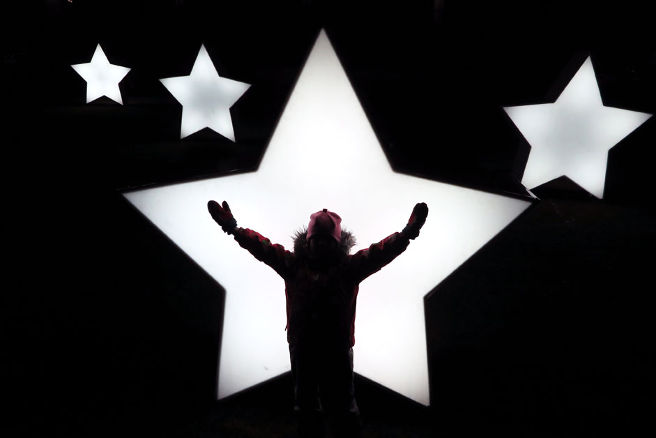 A child plays in front of illuminated stars set up in Gorky park in Moscow, Russia, as preparation for the winter holiday season.