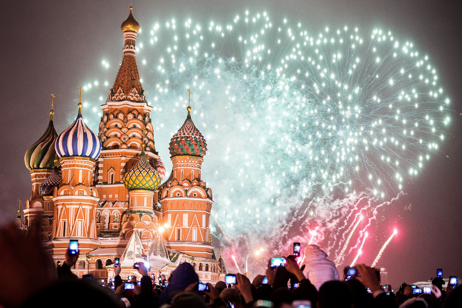 Хора гледат фойерверките на Червения площад през новогодишната нощ. 