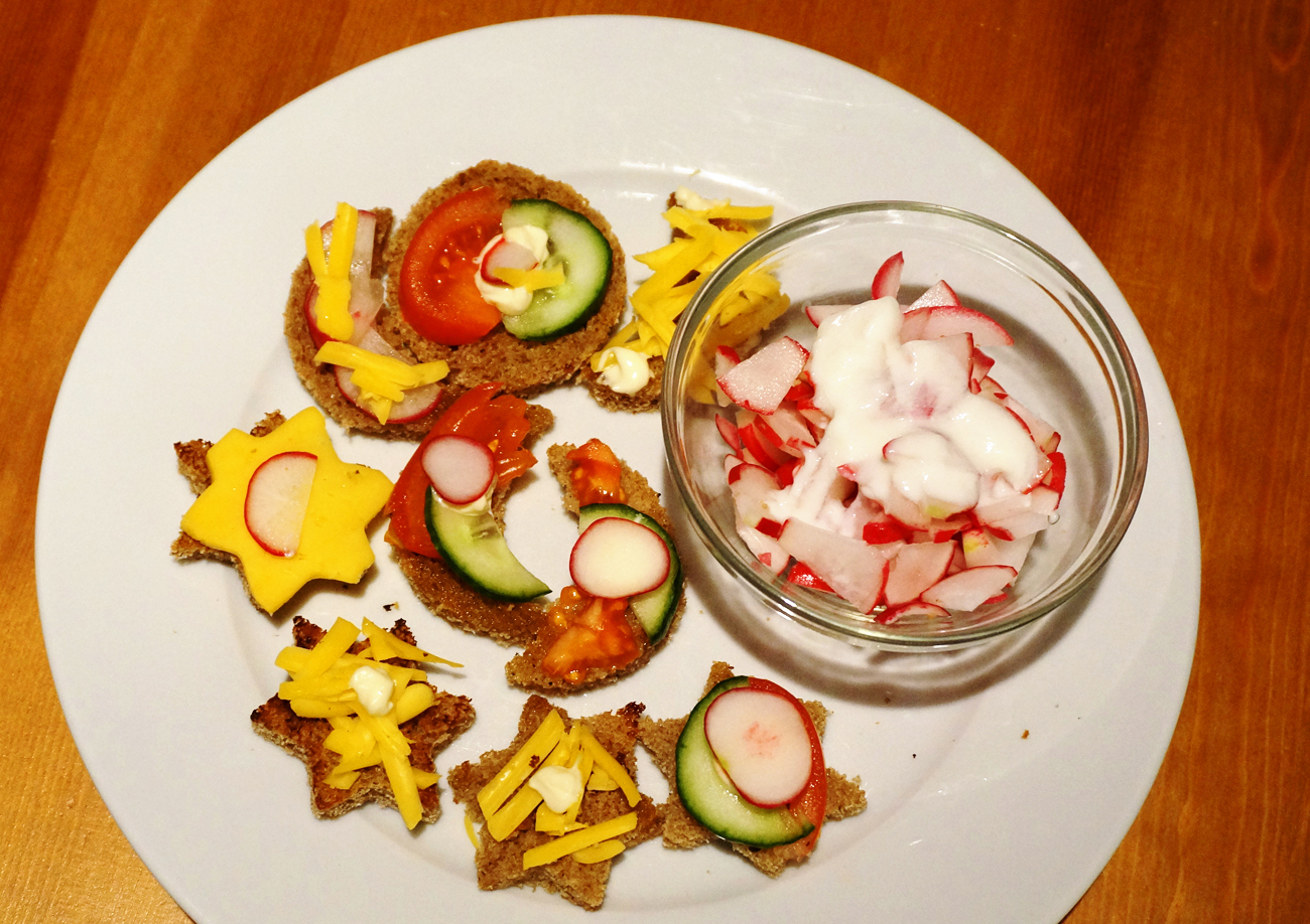 Salad with radishes and sour cream, sandwiches on toasted bread.