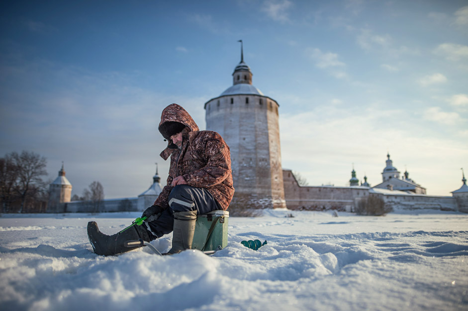 An ice fisherman on the ice of Lake Siverskoye, near the Kirillo-Belozersky Monastery in Vologda Region