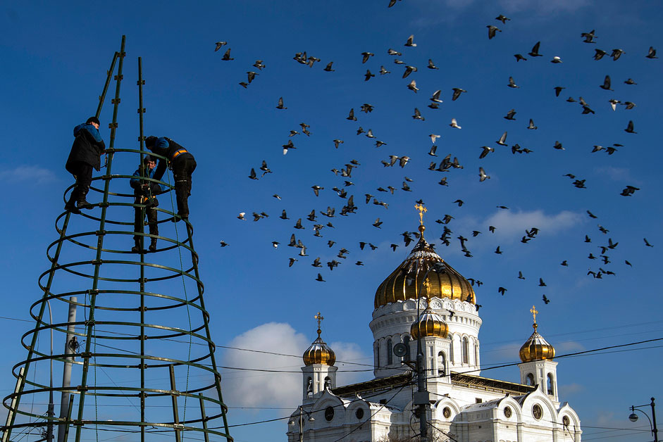 Комунални работници ги симнуваат Божиќните украси пред Соборниот храм Христос Спасителот во Москва.
