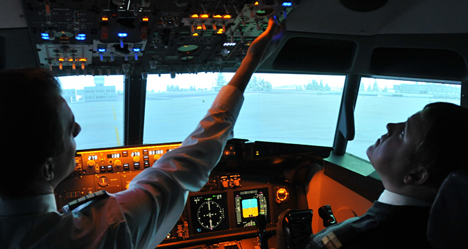 Para siswa melatih diri mereka sendiri melalui simulator pelatihan pilot di Universitas Penerbangan Sipil Sankt Peterburg, Rusia.