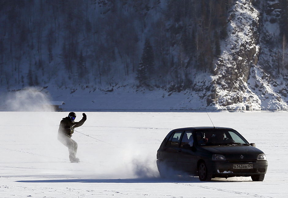 Автомобил влече сноубордер врз замрзнатата површина на реката Енисеј низ сибирската тајга на температура од -25 степени Целзиусови на 31 јануари 2016 во околината на Краснојарск, Сибир, Русија. 