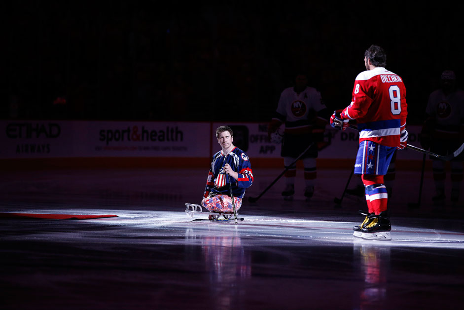 Joschua Misiewicz (l.) vom US-amerikanischen Sledge-Eishockey-Nationalteam wartet vor dem NHL-Spiel gegen die New York Islanders auf Alexander Owetschkin (r.) von den Washington Capitals für den zeremoniellen Einwurf des Pucks.