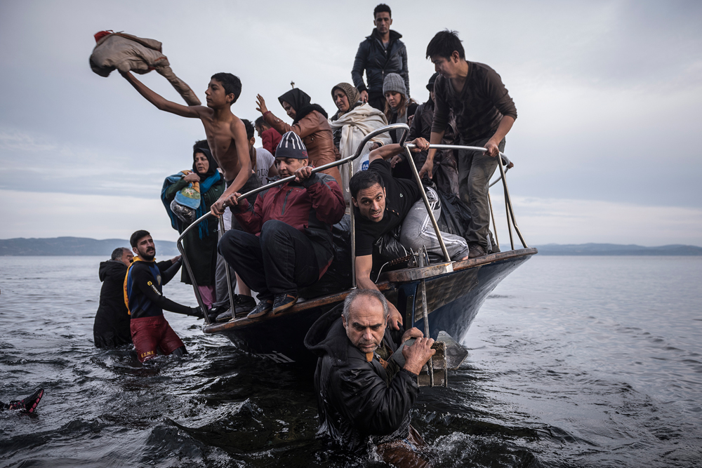 In this image released by World Press Photo titled "Reporting Europe's Refugee Crisis" by photographer Sergey Ponomarev for The New York Times which won the first prize in the General News Stories category shows refugees arriving by boat near the village of Skala on Lesbos, Greece, 16 November 2015.