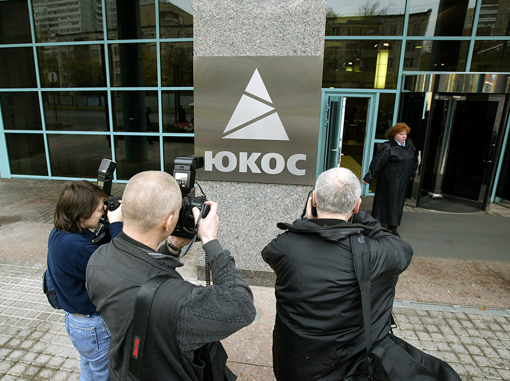 Des journalistes photographient le logo de Ioukos. 
