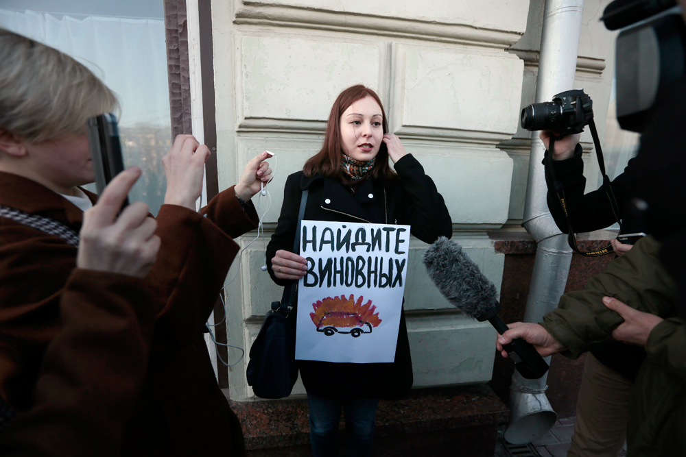 Eine Menschenrechtsaktivistin protestiert vor der Präsidialverwaltung in Moskau. Auf ihrem Plakat steht: „Machen Sie die Schuldigen ausfindig!“