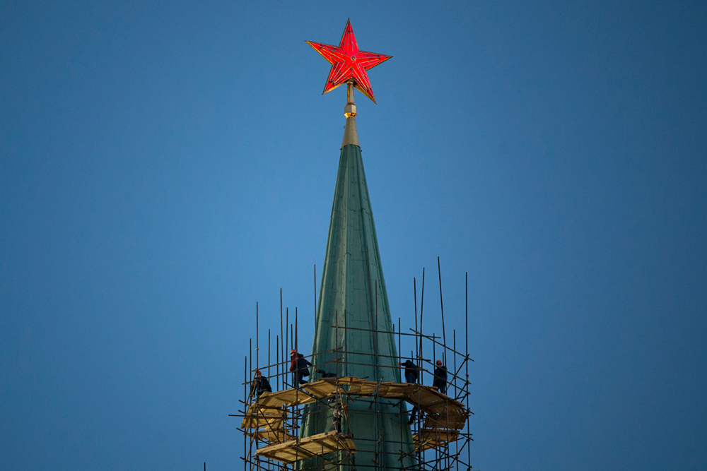 Workers restore a spire of the Nikolskaya Tower in the Kremlin in Moscow, Russia, Thursday, March 10, 2016.