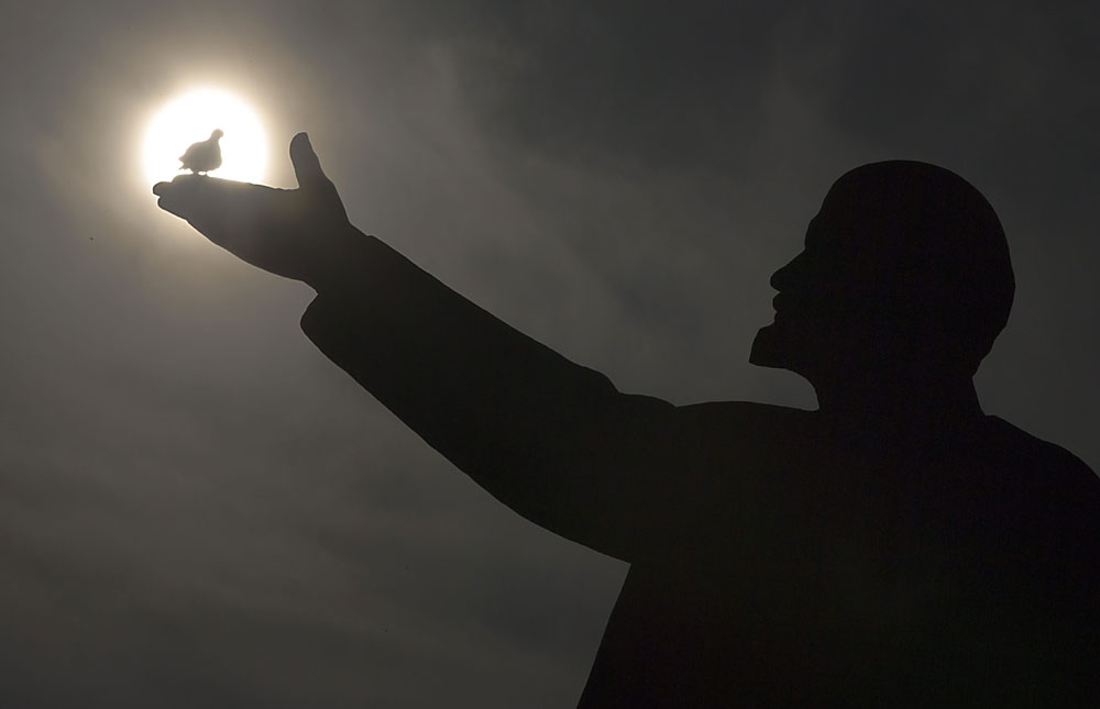 A bird silhouetted by the sun sits on the hand of a statue of Soviet Union founder Vladimir Lenin in Russian leased Baikonur cosmodrome, Kazakhstan, Saturday, March 12, 2016. The start of the new Soyuz mission to the International Space Station is scheduled for Saturday March 19
