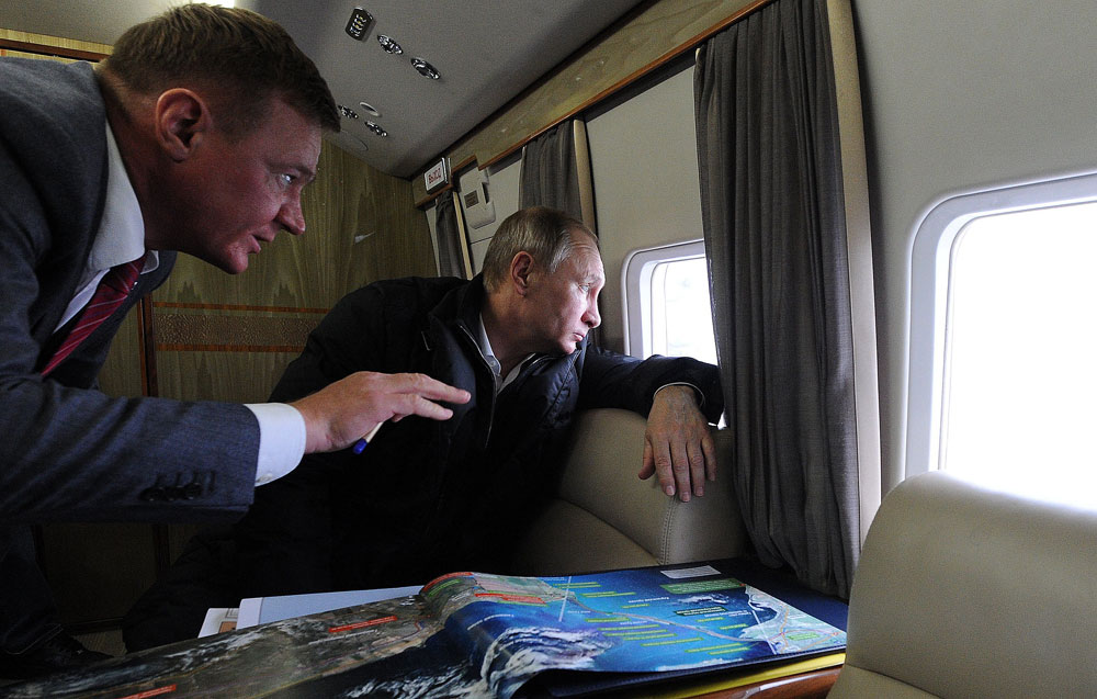 Russian President Vladimir Putin (R) and Rosavtodor Federal Highway Agency head Roman Starovoit (L) inspect the the bridge connecting Taman and Kerch while in flight over the Kerch Strait in Russia