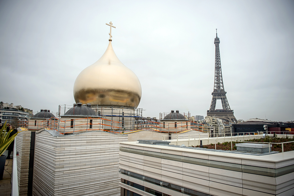  Поставување на златна купола на руска православна црква во Париз, Франција, додека во позадина се гледа Ајфеловата кула. 