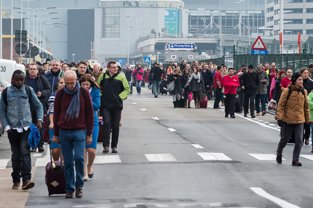 I passeggeri lasciano l'aeroporto di Bruxelles colpito dai terroristi.