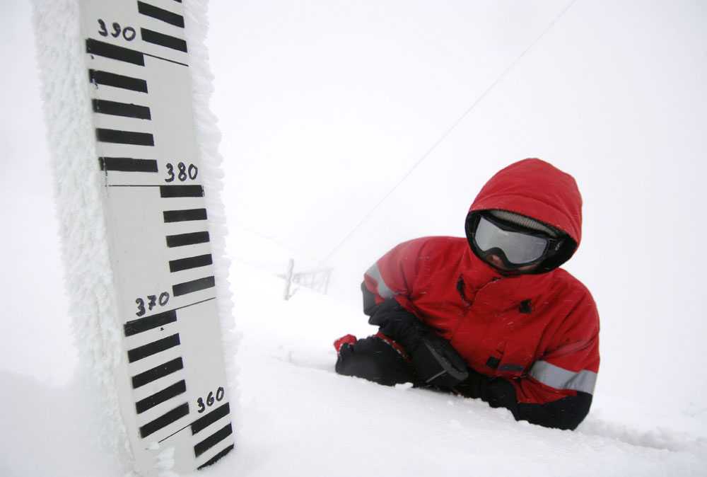 An employee measures the snow cover depth at the Aibga weather station in the Caucasus Mountains outside Sochi.