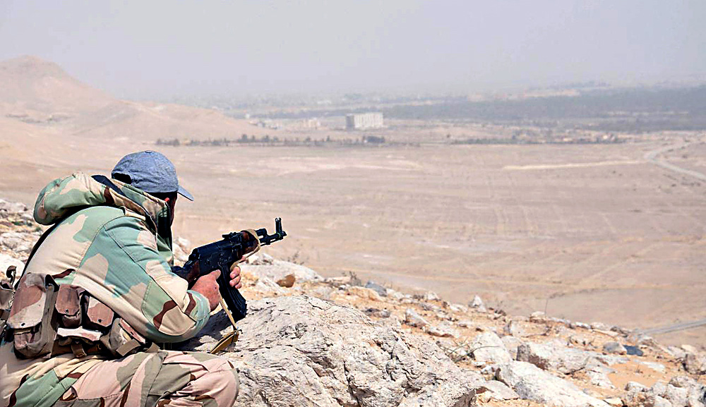 A member of the Syrian army taking position during an advance further in the vicinity of the ancient city of Tadmur (Palmyra), a UNESCO world Heritage site, in central Homs province.