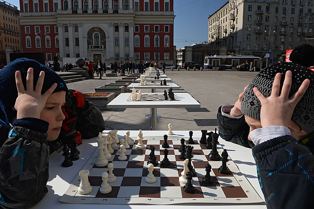 Деца играят шах на Тверски площад в Москва.