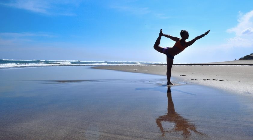 Seorang warga Rusia melakukan yoga di pantai Bali.