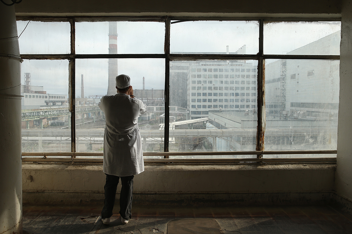 A tourist takes pictures of the first and second reactors of the Chernobyl nuclear station on September 29, 2015. The exclusion zone around the plant has seen around 40 thousands of tourists in the last 10 years. However, the radiation background still exceeds normal values by up to 30 times.