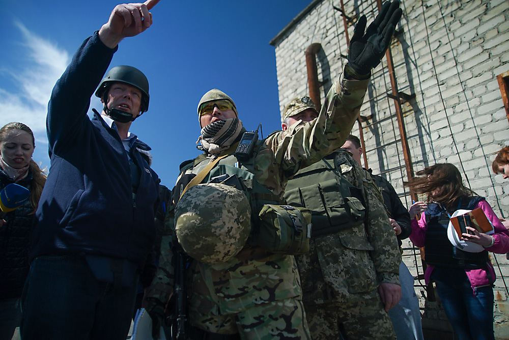 Александар Хаг, шеф на Мисијата за мониторинг на ОБСЕ во Украина (лево) и украински војници, членови на Здружениот центар за контрола и координација покажуваат во насока на новоинсталирана камера за набљудување на ОБСЕ за регистрирање на нарушувањето на прекинот на огнот во Авдиивка, источна Украина.  