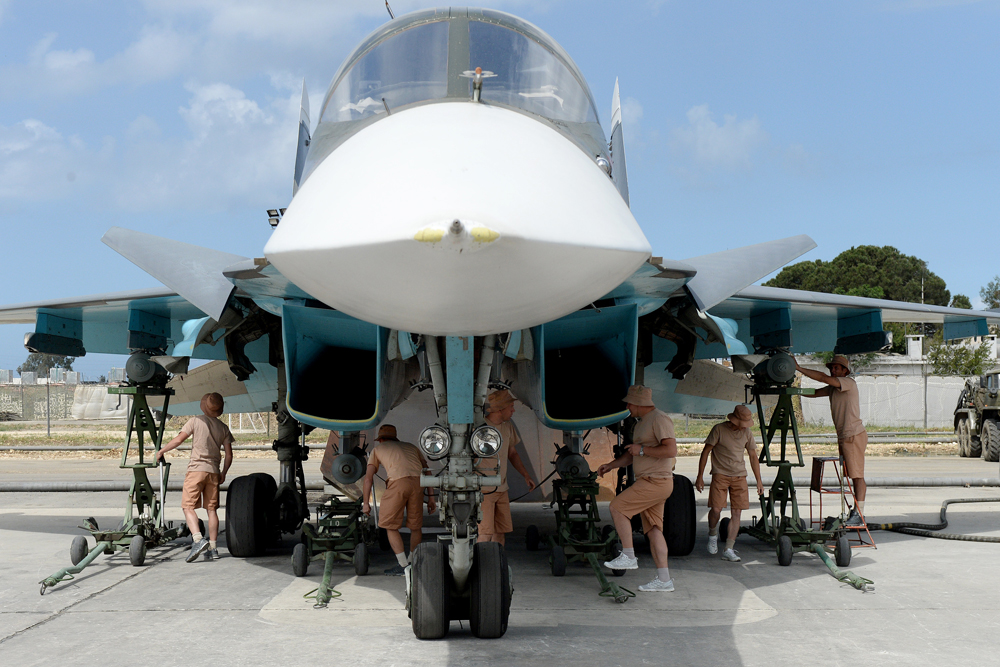 Russian servicemen prepare an Su-34 fighter jet for a mission from the Russian Hmeimim military base in Latakia province, in the northwest of Syria on May 4, 2016. 