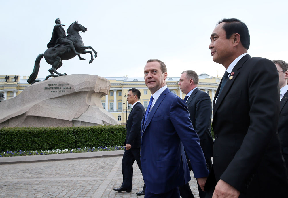 Foreground, from left: Russian Prime Minister Dmitry Medvedev and Prime Minister of Thailand Prayut Chan-o-cha near the Bronze Horseman, an equestrian statue of Peter the Great, on Senate Square in St. Petersburg.
