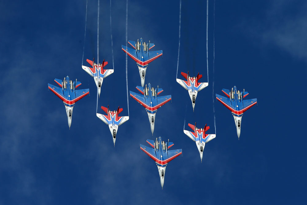  Mikoyan MiG-29 fighter jets of the Strizhi [Swifts] and Sukhoi Su-27 fighter jets of the Russkiye Vityazi [Russian Knights] aerobatic teams perform during an event marking the 25th anniversary of the Strizhi [Swifts] and Russkiye Vityazi [Russian Knights] aerobatic teams, at Kubinka air base in the Moscow Region, Russia