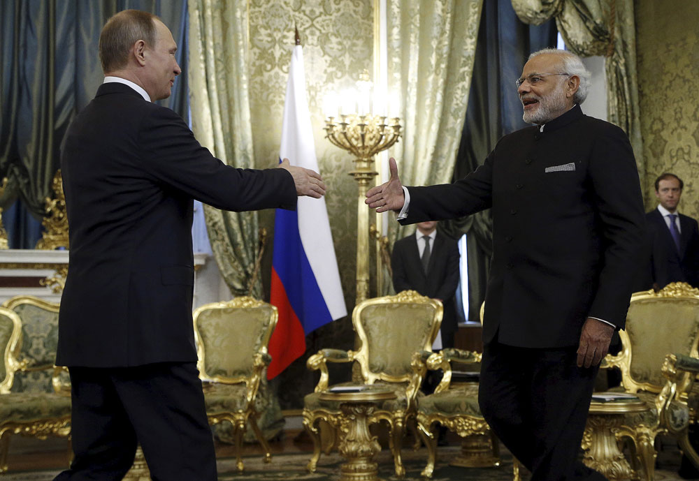 Russia's President Vladimir Putin (L) shakes hands with India's Prime Minister Narendra Modi during a meeting at the Kremlin in Moscow, Russia