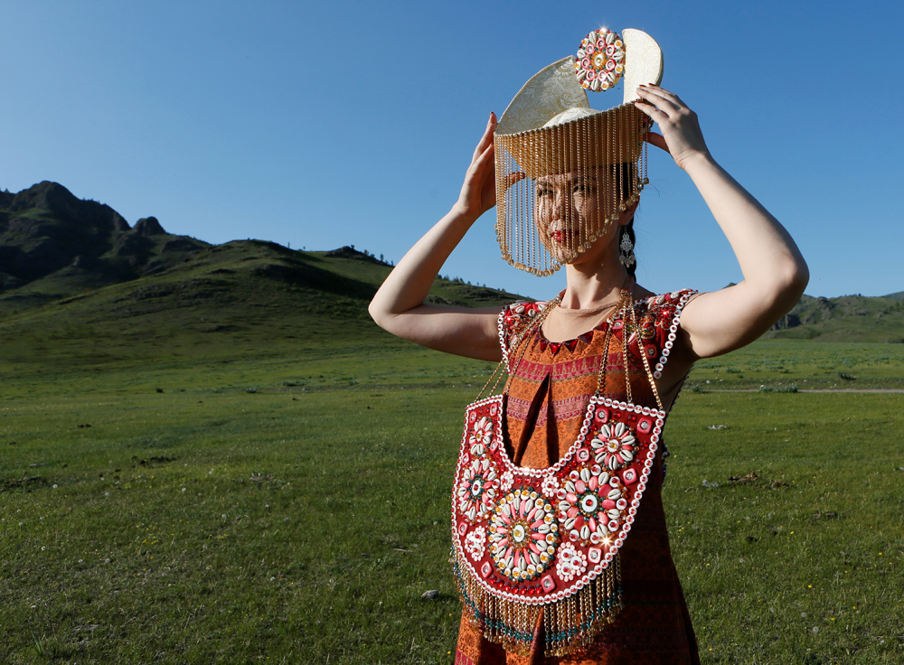 A model of the "Altyr" fashion theatre, dressed in a Khakas national costume, poses during a photo session, as a part of the rehearsal for the Tun-Pairam traditional holiday (The Holiday of the First Milk) celebration at a museum preserve outside Kazanovka village near Abakan in the Republic of Khakassia, Russia, May 28, 2016. The museum preserve is located in a picturesque forest-steppe valley near the Abakan ridge of the Kuznetsk Alatau mountain range and displays numerous objects of the cultural and historical heritage of various epochs accumulated by the people living on this territory, according to representatives