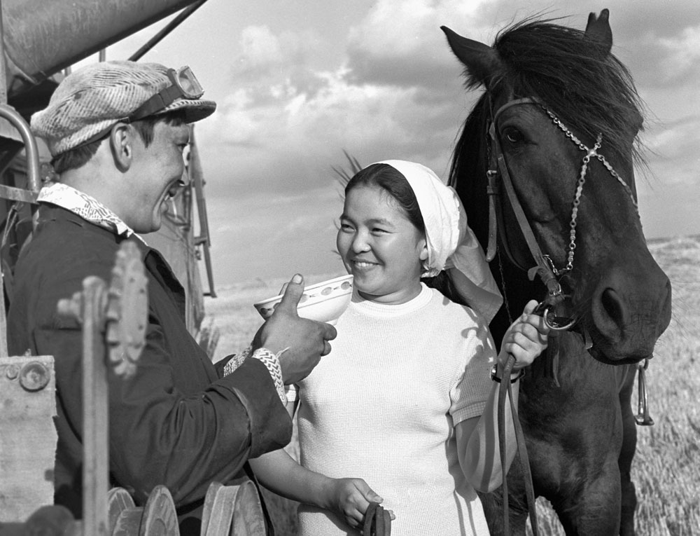 1976. A milkmaid from Kazakhstan offers a bowl of kumis to a combine driver. 