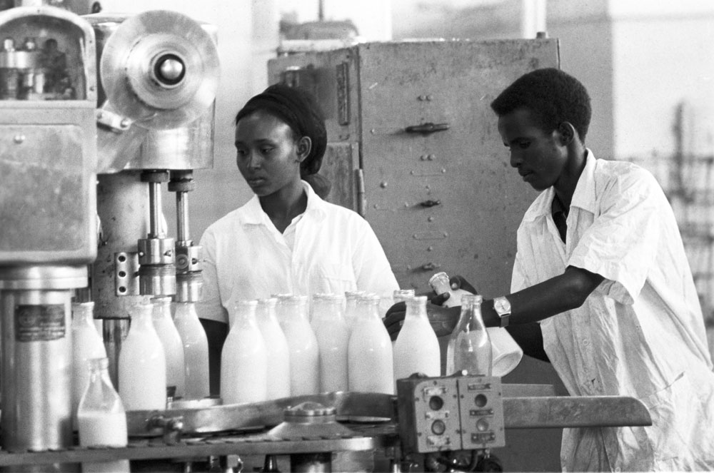 1974. Dua orang buruh pabrik pengolahan susu di Mogadishu, Somalia. Pabrik ini dibangun oleh insinyur Soviet.