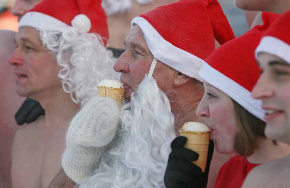 Members of the Spektr cold training club and Polar Dolphins winter swimming federation, dressed as Father Frosts, eating ice-cream during their New Year race in Novosibirsk.