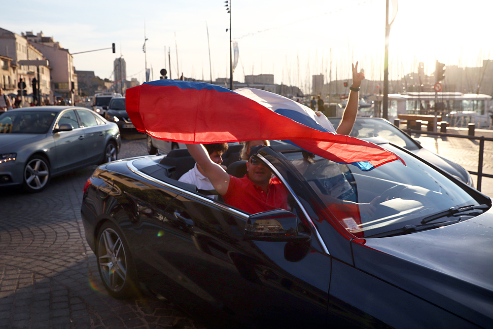 Russian football fans hold a flag as they drive in Marseille ahead of the England v Russia game on Saturday, on June 9, 2016 in Marseille, France. Football fans from around Europe have descended on France for the UEFA Euro 2016 football tournament.