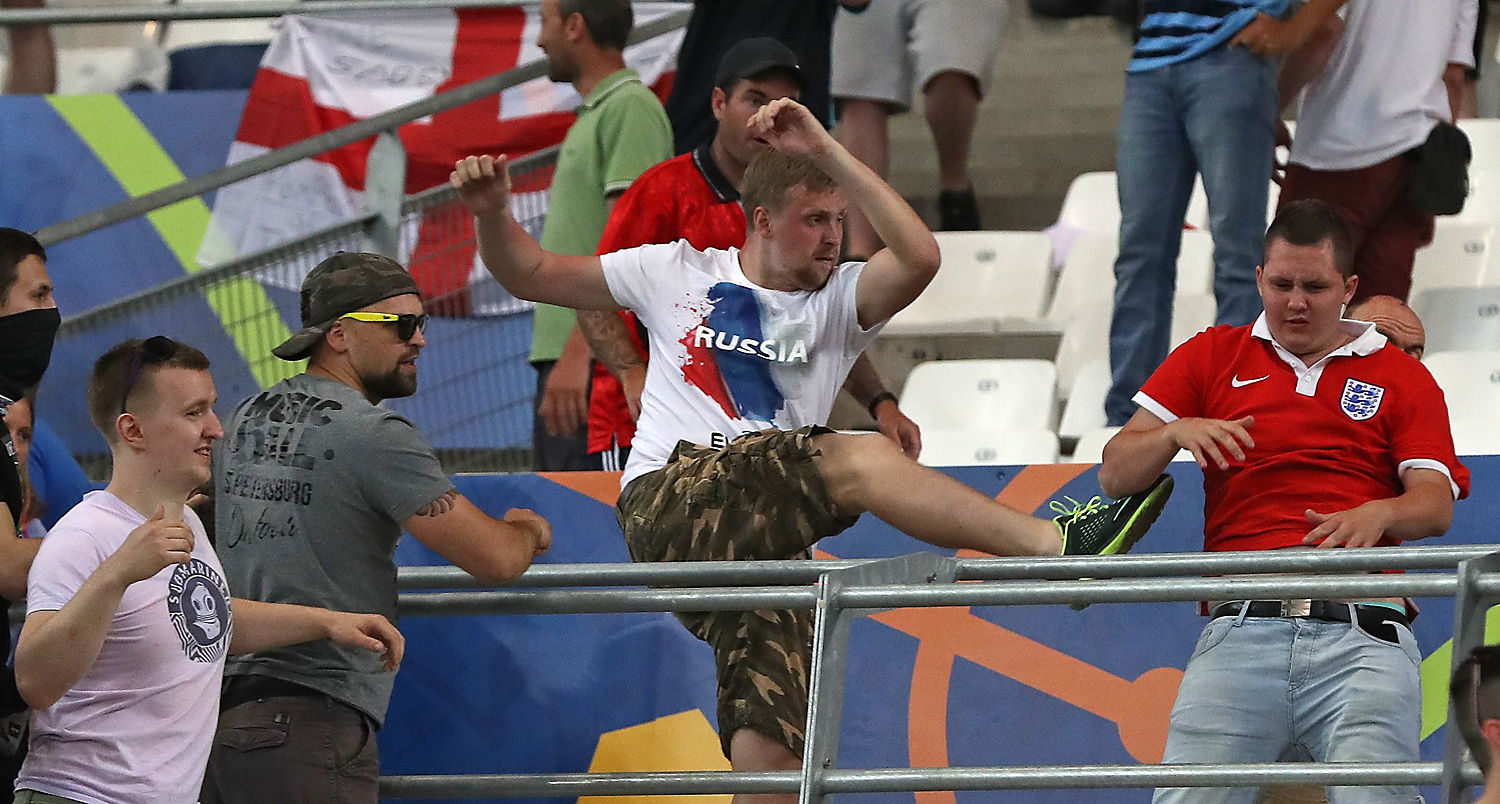 June 11, 2016 file photo, Russian supporters attack an England fan at the end of the Euro 2016 Group B soccer match between England and Russia, at the Velodrome stadium in Marseille, France. UEFA's disciplinary body says Tuesday, June 14, 2016 Russia will be disqualified from the European Championship if there is more fan violence inside stadiums in France.