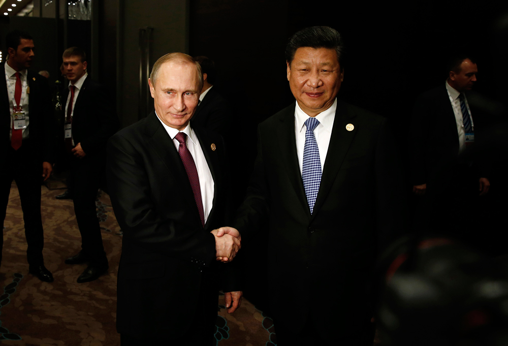 In this Sunday, Nov. 15, 2015 photo, Russian President Vladimir Putin, left, shakes hand with Chinese President Xi Jinping, right, prior to their meeting at the G-20 Summit in Antalya, Turkey. The leaders of the Group of 20 were wrapping up their two-day summit in Turkey Monday against the backdrop of heavy French bombardment of the Islamic State's stronghold in Syria. The bombings marked a significant escalation of France's role in the fight against the extremist group. 