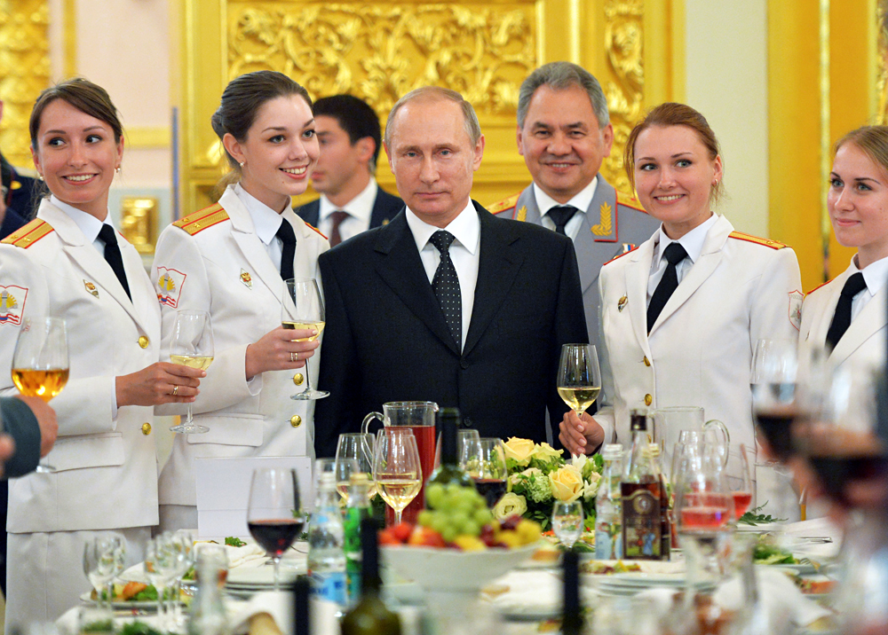 Russian President Vladimir Putin (C) and Defense Minister Sergei Shoigu (back) attend a reception to honor graduates of military academies at the Kremlin in Moscow on June 28, 2016. 