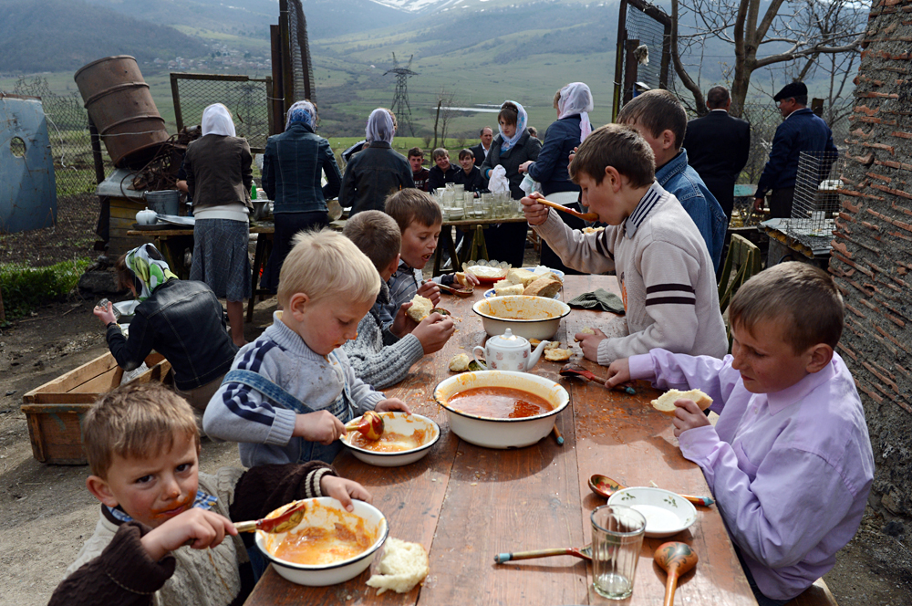 Des enfants moloques lors d'un repas de commémoration après les funérailles d'un co-villageois.
