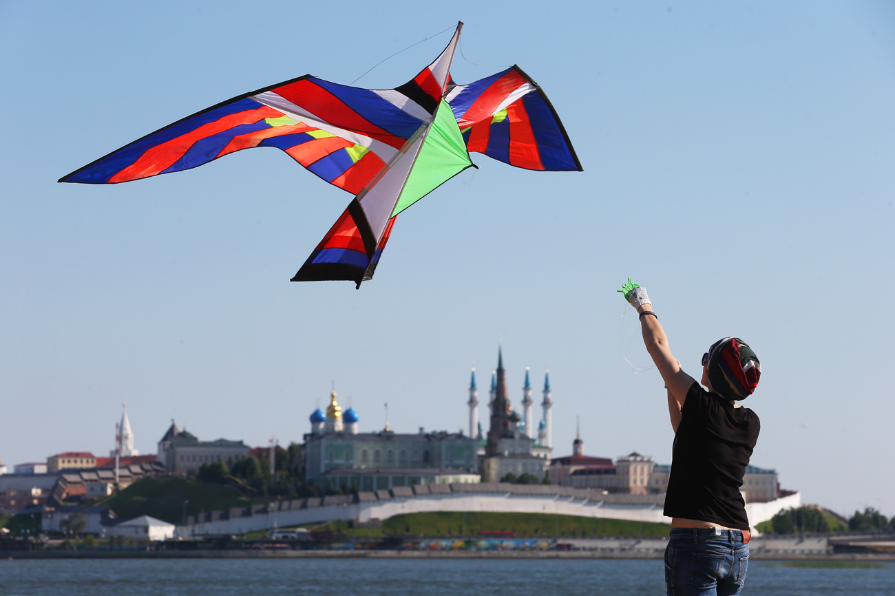 KAZAN, RUSSIA - JULY 16, 2016: A woman flying a kite takes part in the Easy to Fly kite festival. 