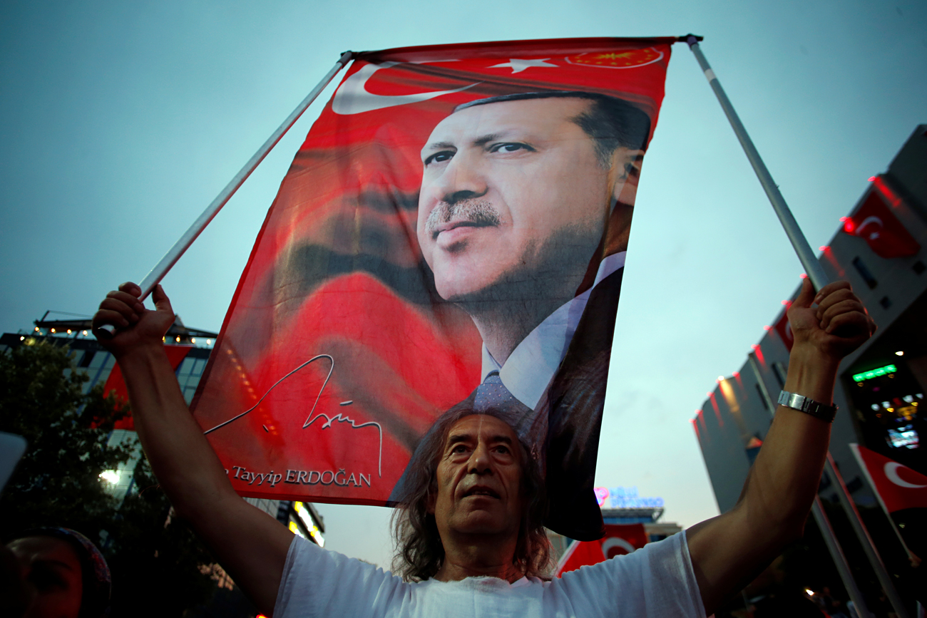 2016년 7월 20일 터키 수도 앙카라에서 친 정부 시위대가 구호와 함께 터키국기와 에르도안 대통령의 사진을 흔들고 있다.