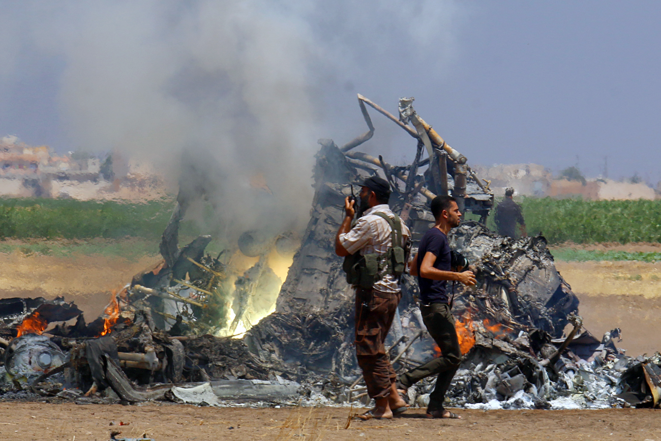 Men inspect the wreckage of a Russian helicopter that had been shot down in the north of Syria's rebel-held Idlib province, Syria, August 1, 2016.
