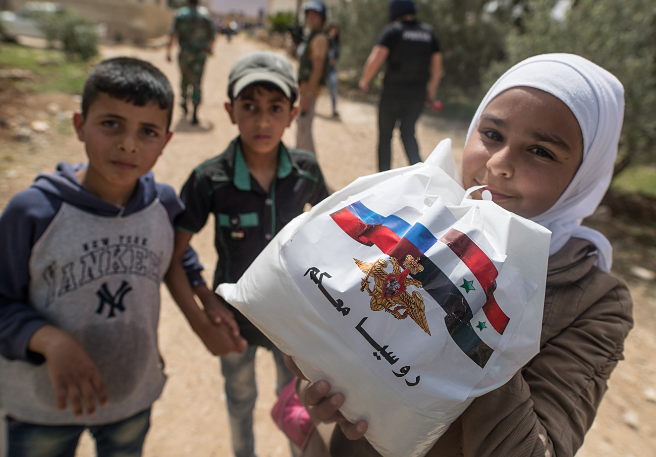 DARAA GOVERNORATE, SYRIA. Syrian children receive Russian humanitarian aid in the settlement of Alkin. 