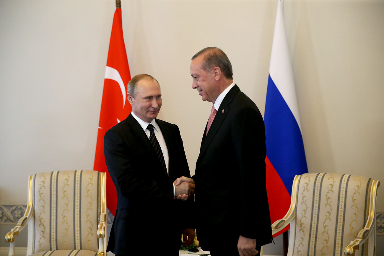 Presiden Rusia Vladimir Putin (kiri) dan Turki Presiden Recep Tayyip Erdoğan berjabat tangan selama pertemuan di Istana Konstantin, Sankt Peterburg, 9 Agustus 2016.
