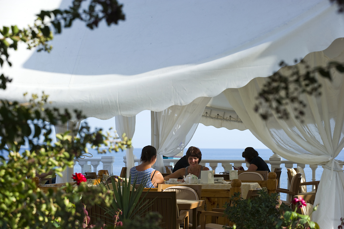 Holidaymakers at a cafe of the Relax Center Irei hotel in Semidvorye near Alushta, Crimea.