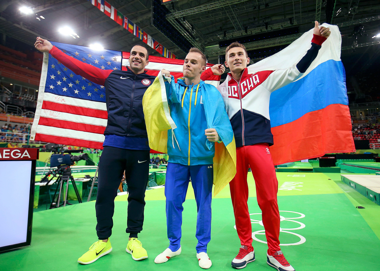 Ukrajinski športnik Oleg Vernjajev, ameriški športnik Danell Leyva ter ruski športnik David Beljavskij so se takole objeli, ko so praznovali zmago v finalu  moške paralelne bradlje na Olimpijskih igrah v Riu.
