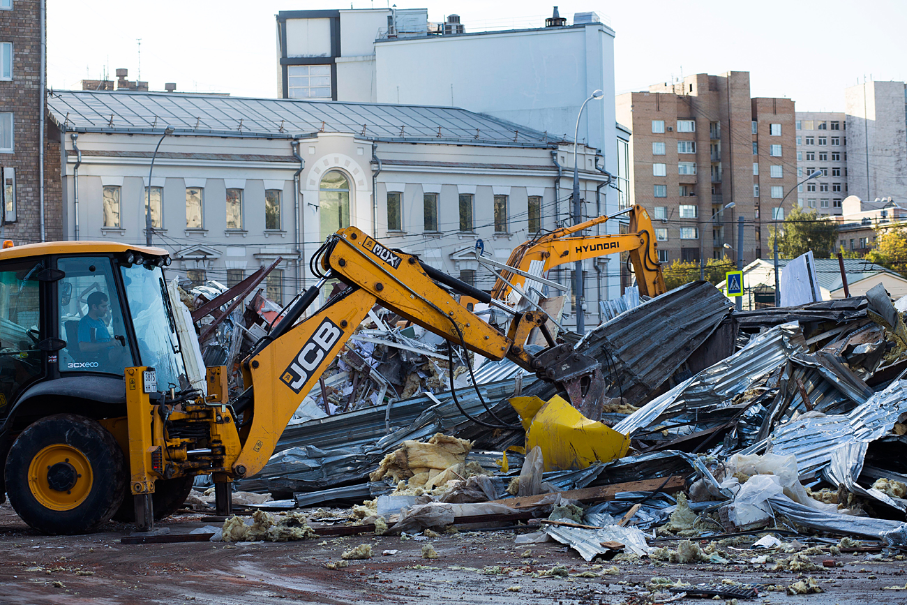 Municipal workers carry out debris of flattened kiosks built without formal planning permission on the ground near a subway station in Moscow, Aug. 29, 2016. 
