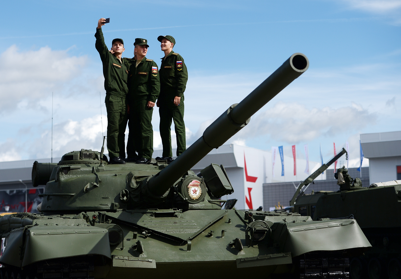 Военни се снимат на фона на Т-80.