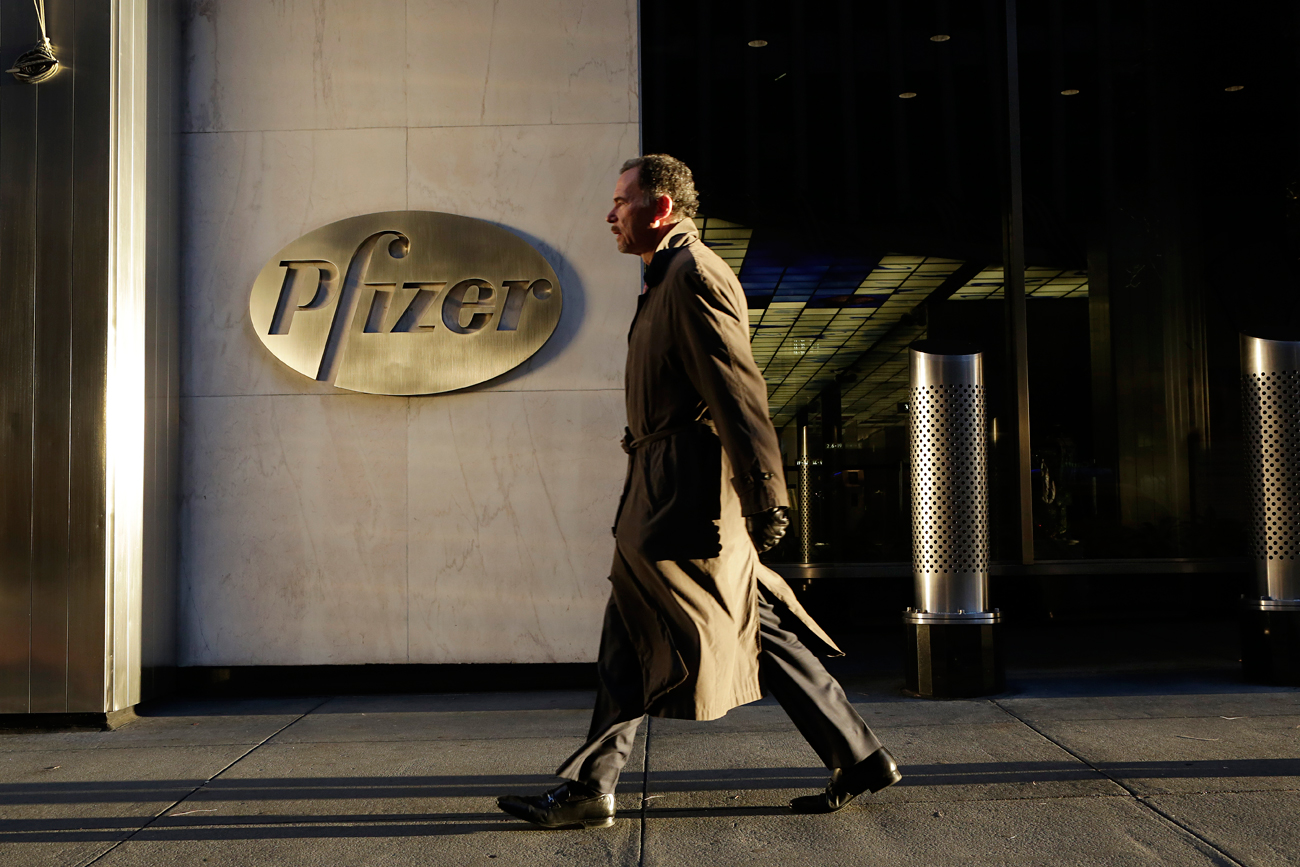 A man walks past Pfizer World Headquarters, New York.
