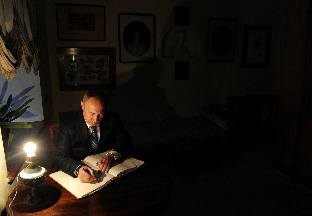 Russian President Vladimir Putin signs a visitors' book at Russian writer Leo Tolstoy estate museum in Yasnaya Polyana outside the city of Tula, Russia