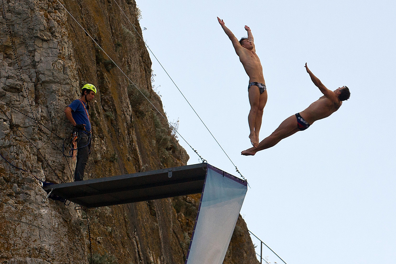 Спортисти тренираат скок во вода од карпата Дива во Симеиз, Крим.