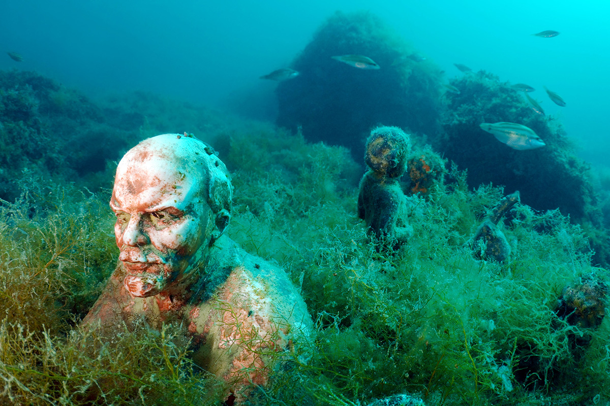 A diversi metri di profondità si incontrano mezzi busti di statue, ormai ricoperti da alghe e pesci