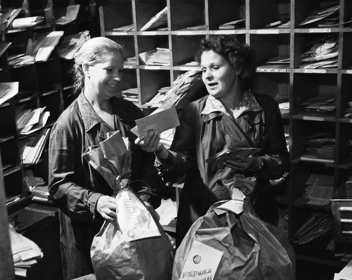 1963. Des employés de la poste trient le courrier. 